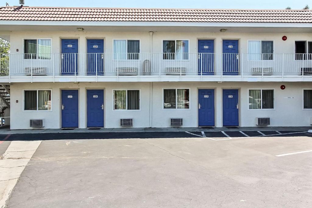 una fila de puertas azules en un edificio blanco en Motel 6-Campbell, CA - San Jose, en Campbell