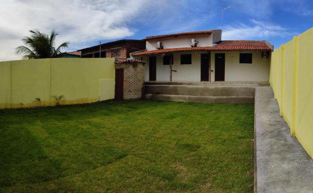 um quintal de uma casa com uma cerca em Flats da Paz Maracajaú em Maracajaú