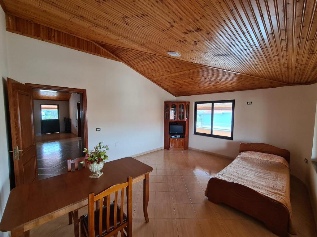 - un salon avec un plafond en bois et une table dans l'établissement Bar Kafe Pjetri Guest House, à Patza-Kuqani