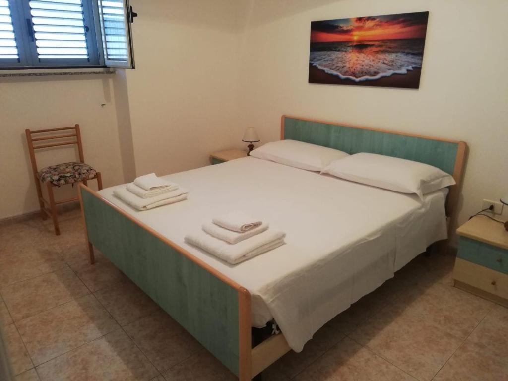 una camera da letto con un letto e due asciugamani di La Meridiana 2 a Marina di Leuca