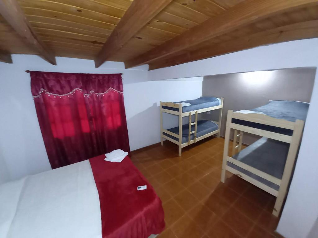 1 dormitorio con 2 literas y cortina roja en Apart Clavel del Aire en Puerto Iguazú