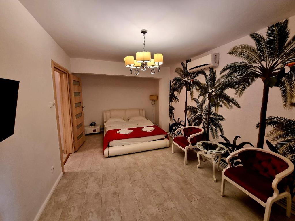 1 dormitorio con cama, sillas y lámpara de araña en Apartament Faleza, en Galaţi