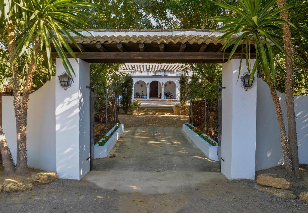 una entrada a una villa con palmeras en La Casa del Valle . Descansar junto a Doñana en plena naturaleza., en Manzanilla