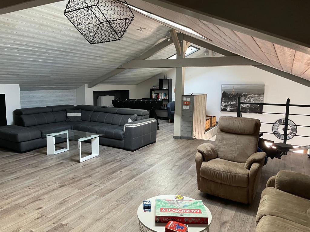 uma sala de estar com um sofá, cadeiras e uma mesa em Duplex avec poêle à granulés et garage à motos em Montaigut-le-Blanc