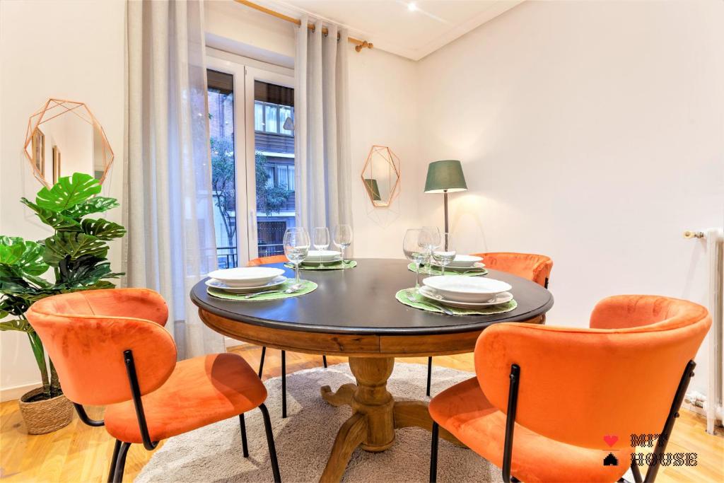 comedor con mesa y sillas naranjas en MIT House Menorca en Madrid, en Madrid