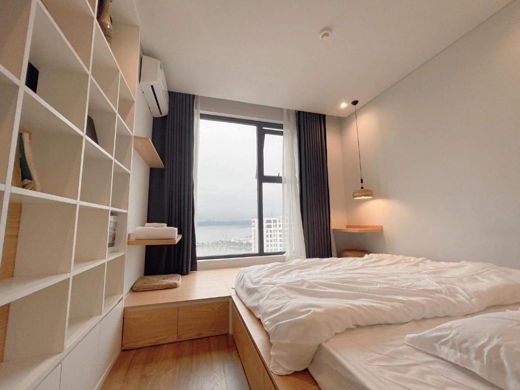- une chambre avec un lit et une grande fenêtre dans l'établissement Bon Homestay View biển Hạ Long, à Hạ Long