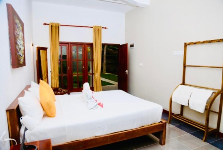 a bedroom with a white bed and a window at Manel Villa in Bentota