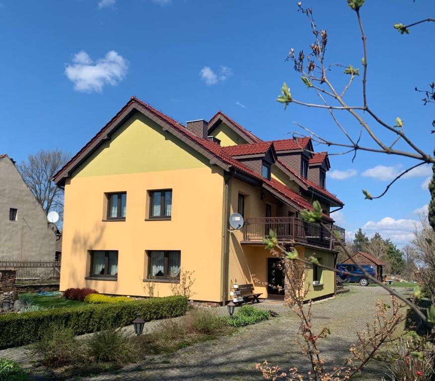 żółty dom z czerwonym dachem w obiekcie Wakacyjny dom w Suchym Borze w mieście Suchy Bór