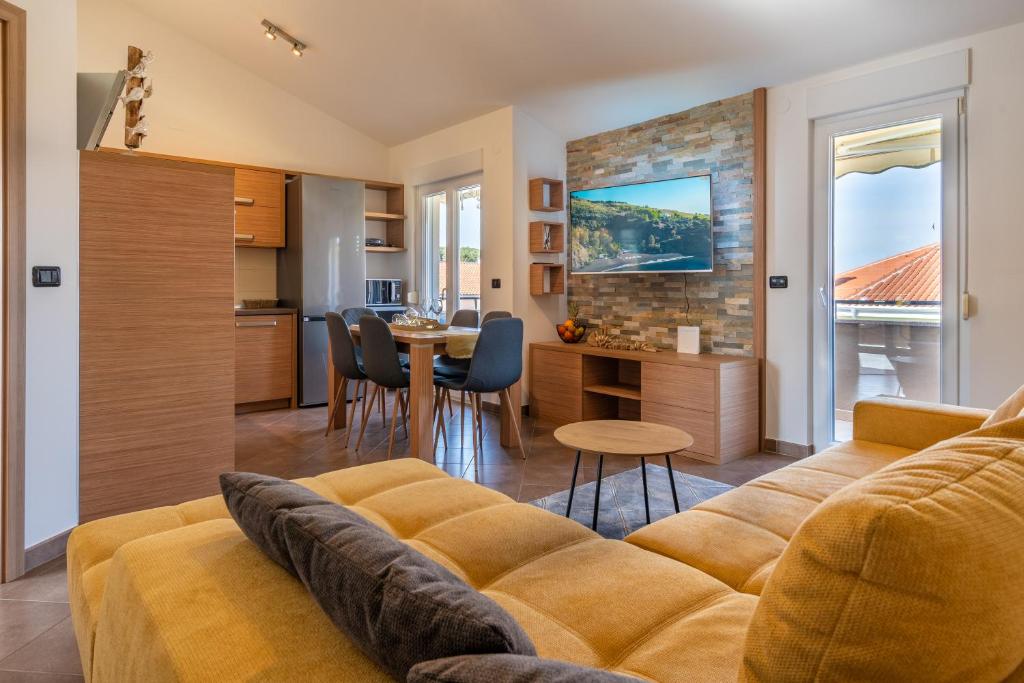un soggiorno e una cucina con divano e tavolo di Penthouse Gea a Premantura