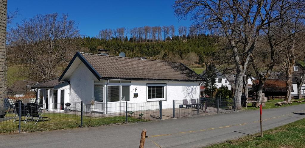 uma pequena casa branca na berma de uma estrada em Villa Winterberg Mollseifen em Winterberg