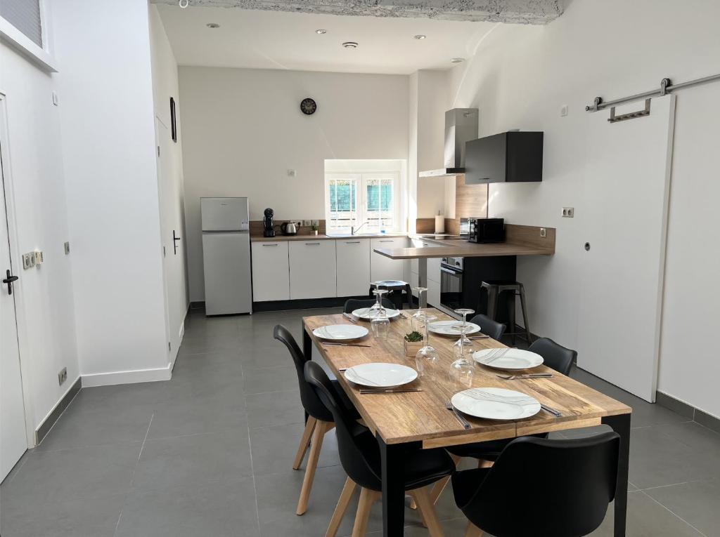 a kitchen with a wooden table and black chairs at LE LOFT - 70m2 T3 Cronenbourg 6 pers in Strasbourg