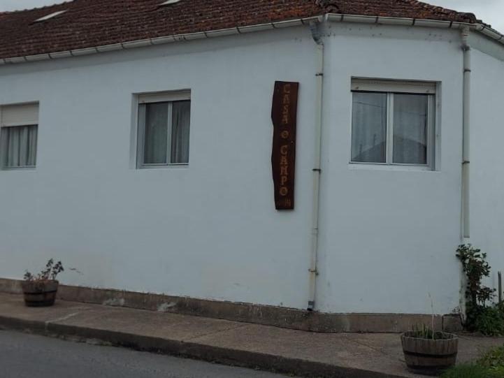 um edifício branco com um sinal na lateral em CASA "O Campo" em Sober