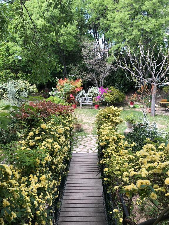 une passerelle en bois traversant un jardin fleuri dans l'établissement B&B Villa Roumanille, à Aix-en-Provence