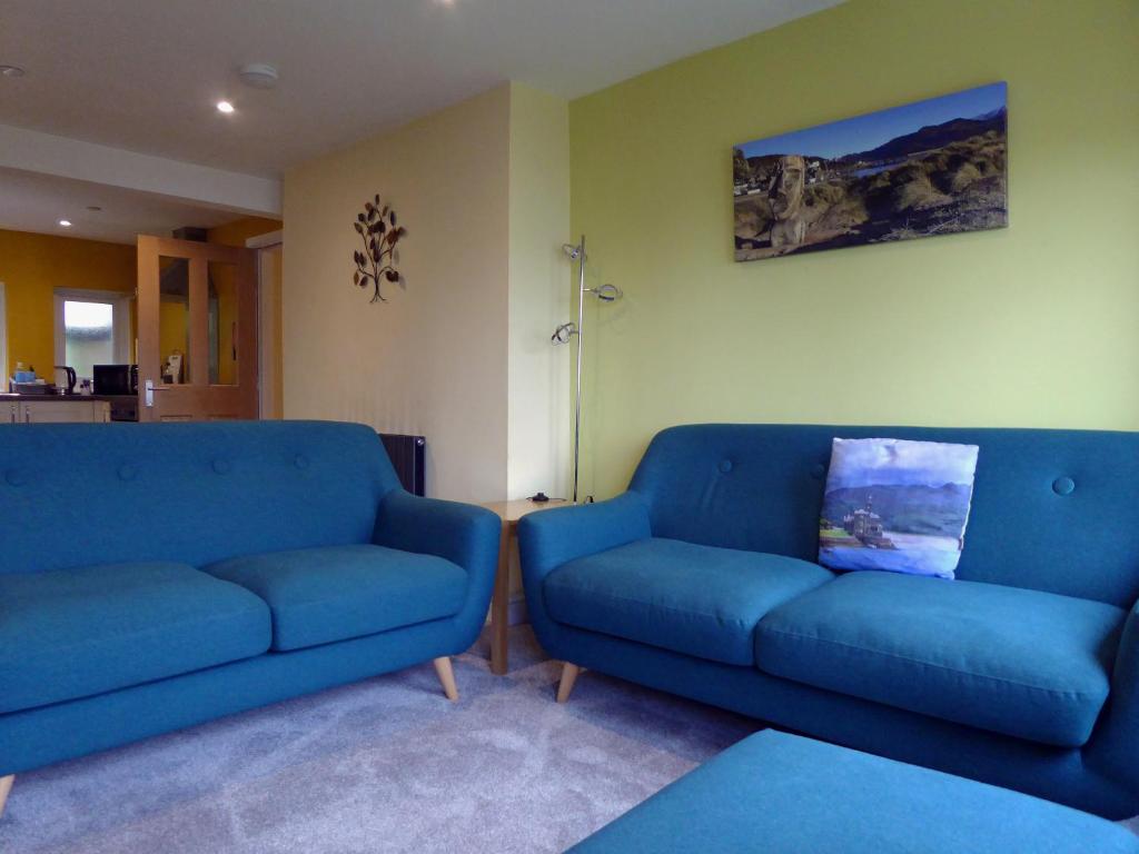 two blue couches sitting in a living room at Bryn Melyn Apartments in Barmouth