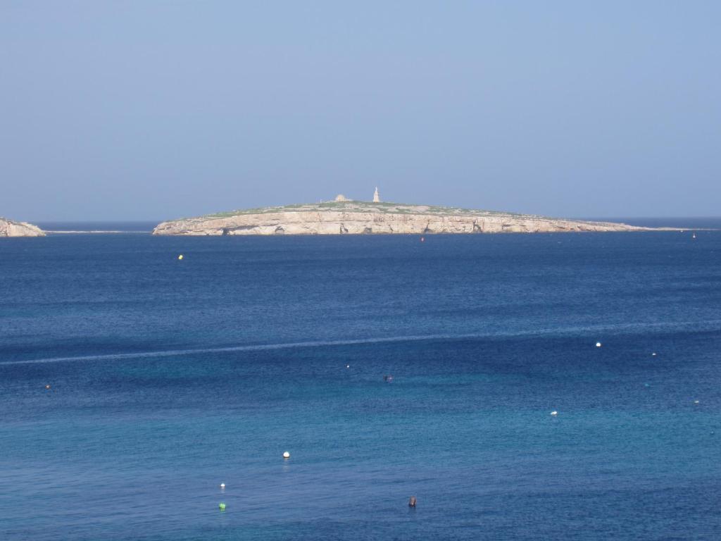 un'isola in mezzo a un grande corpo d'acqua di The Sea Across the Road - Flat 4 a San Pawl il-Baħar