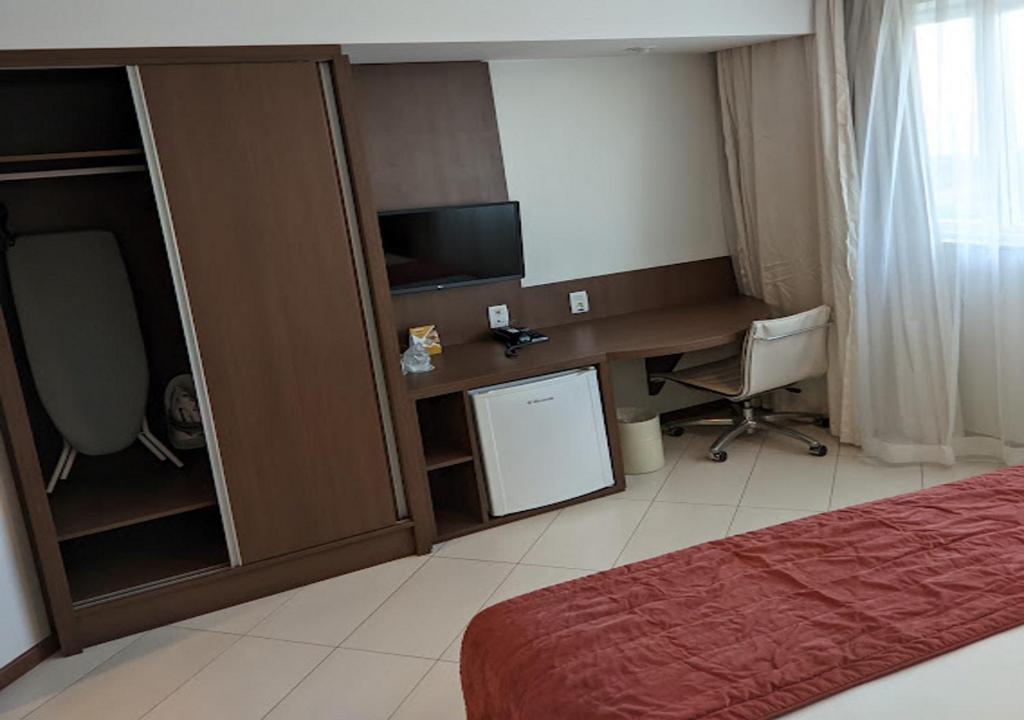 a bedroom with a bed and a television at Quality Hotel Vitória in Vitória