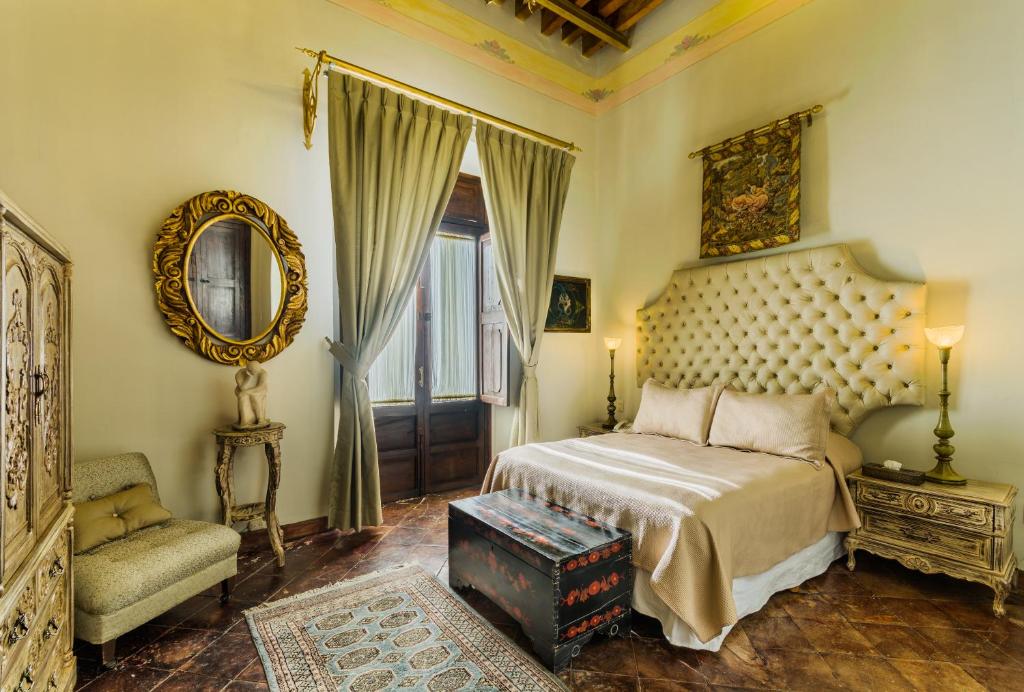 a bedroom with a bed and a chair and a mirror at Casa Pedro Loza in Guadalajara