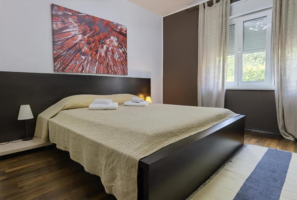 sypialnia z dużym łóżkiem z dwoma ręcznikami w obiekcie Pine and Lime Apartments w Puli