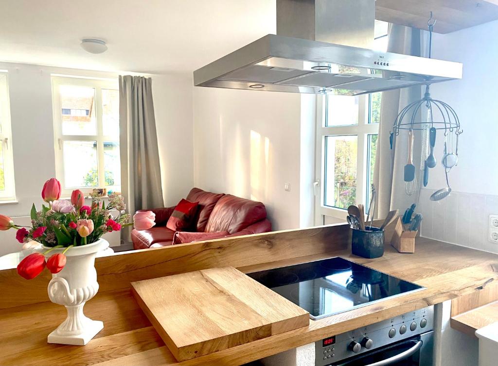 a kitchen with a vase of flowers and a couch at Gronocottage in Bad Harzburg
