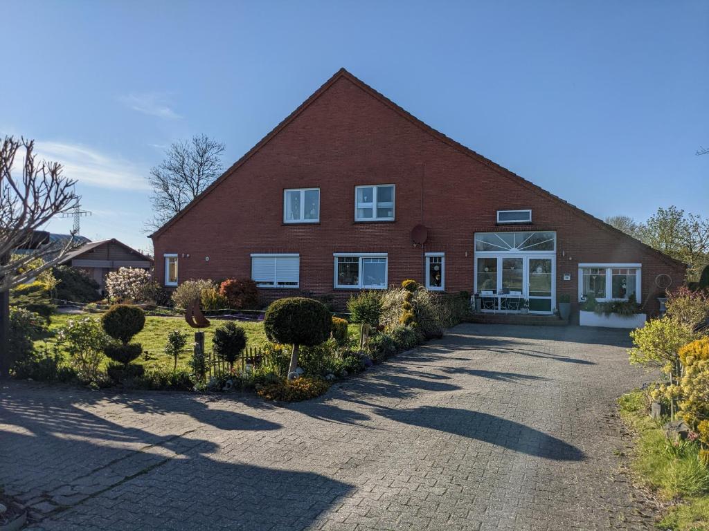a large red brick house with a driveway at Landambiente Hage in Halbemond