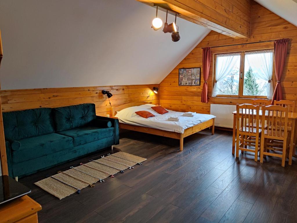 a living room with a couch and a bed at Alpine Escape Studios in Măgura