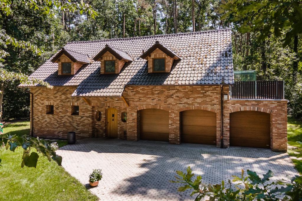 una casa con due porte garage e un tetto di Kersko Apartments a Hradišťko