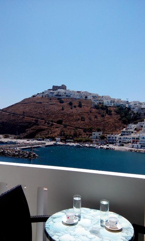 a table with two glasses and a view of a mountain at Ενάλιον in Astypalaia