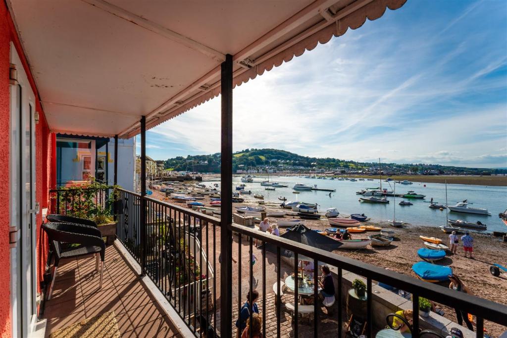 a balcony with a view of a harbor with boats at Crab Shack Apartments - Stylish back beach duplex apartment, Teignmouth in Teignmouth
