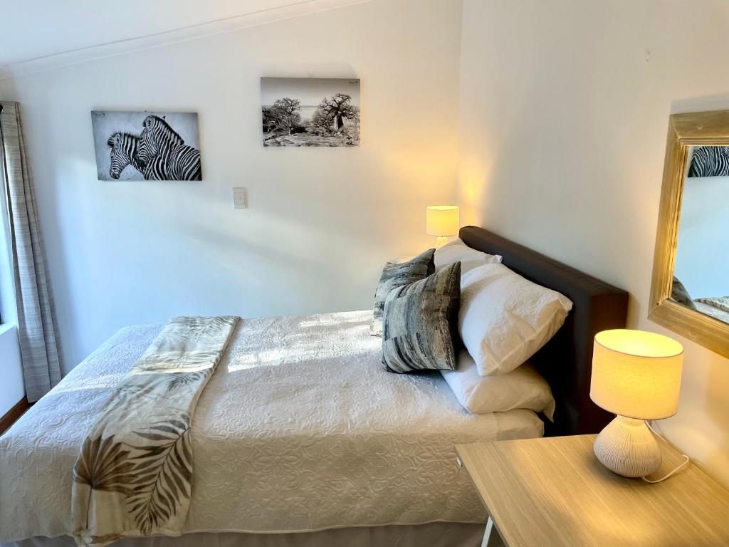 una camera da letto con un letto e un tavolo con una lampada di 17 HAWKES HEAD SELF CATERING a East London