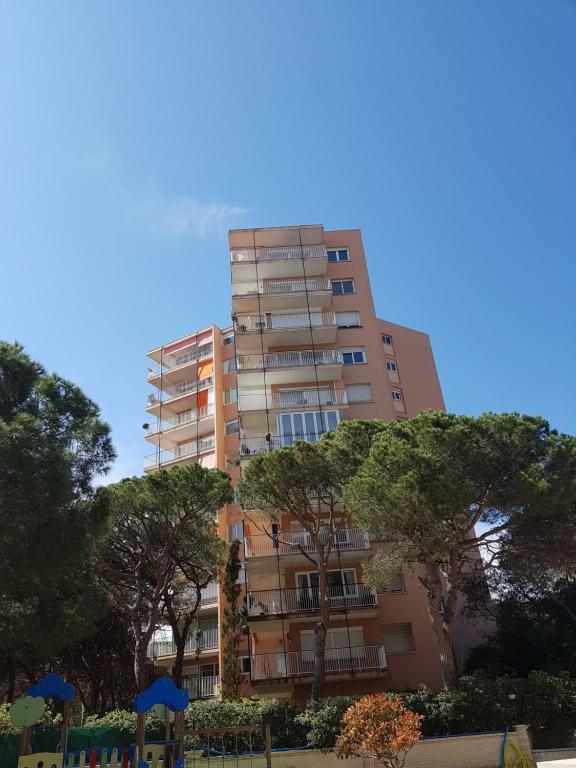 a tall building with trees in front of it at Apartamento en la torre de S`Abanell in Blanes