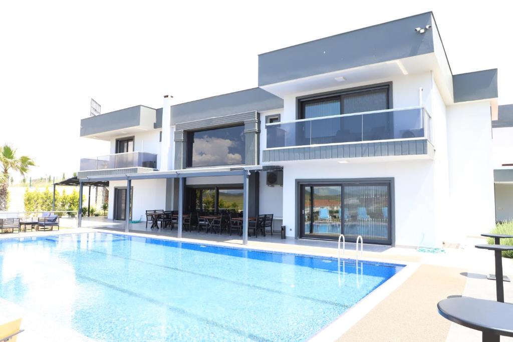 une maison avec une piscine en face de celle-ci dans l'établissement DKD DELÜXE, à Izmir