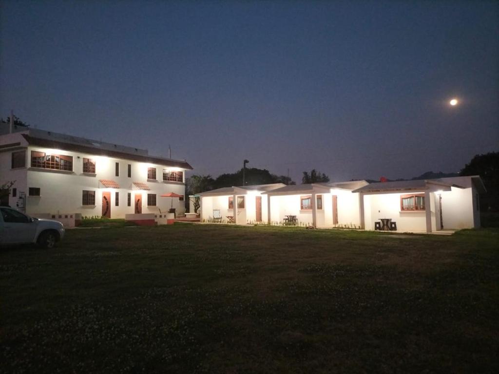 - deux bâtiments blancs la nuit avec une lune dans l'établissement VILLAZOL CABAÑAS, à Zacatlán