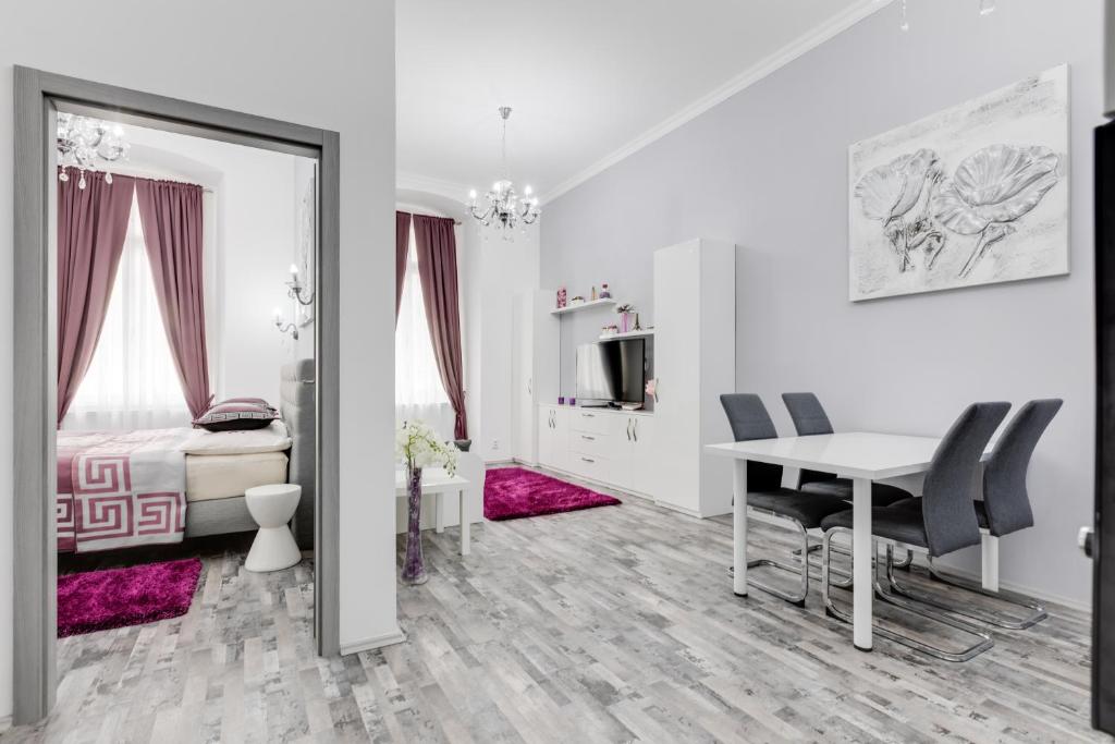 1 dormitorio con 1 cama, mesa y sillas en Apartment Thunovská 10 en Praga