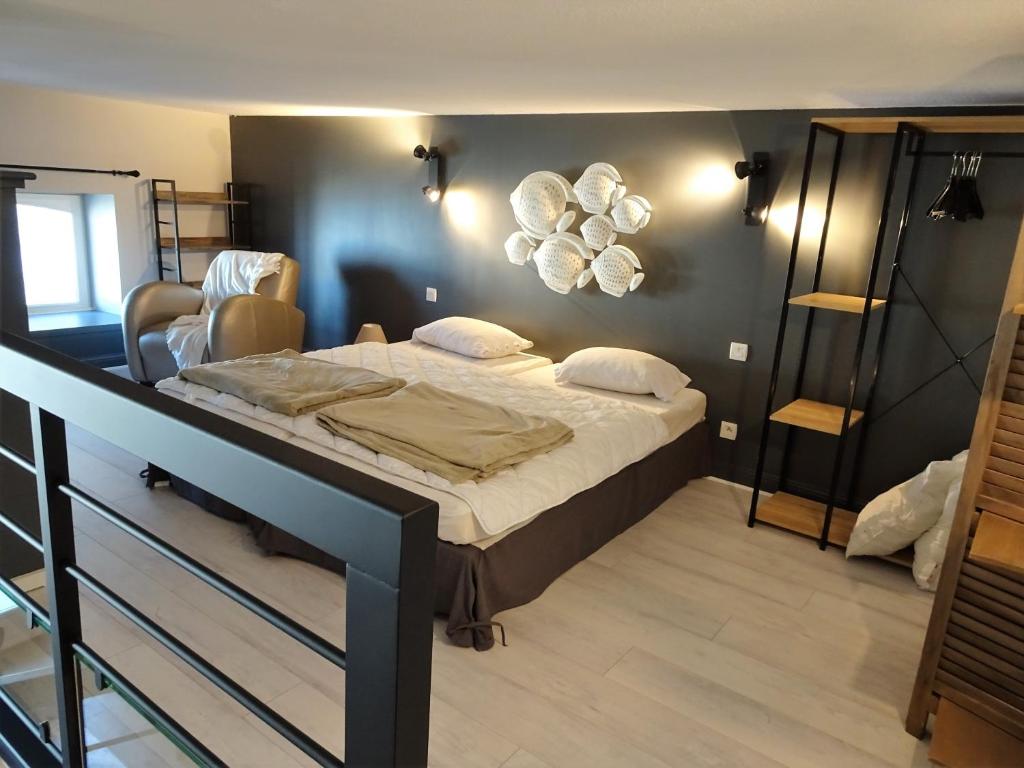 una camera da letto con un letto con uno specchio sul muro di Charmant Studio en duplex esprit loft avec balcon vue mer, et piscine extérieure a Le Croisic