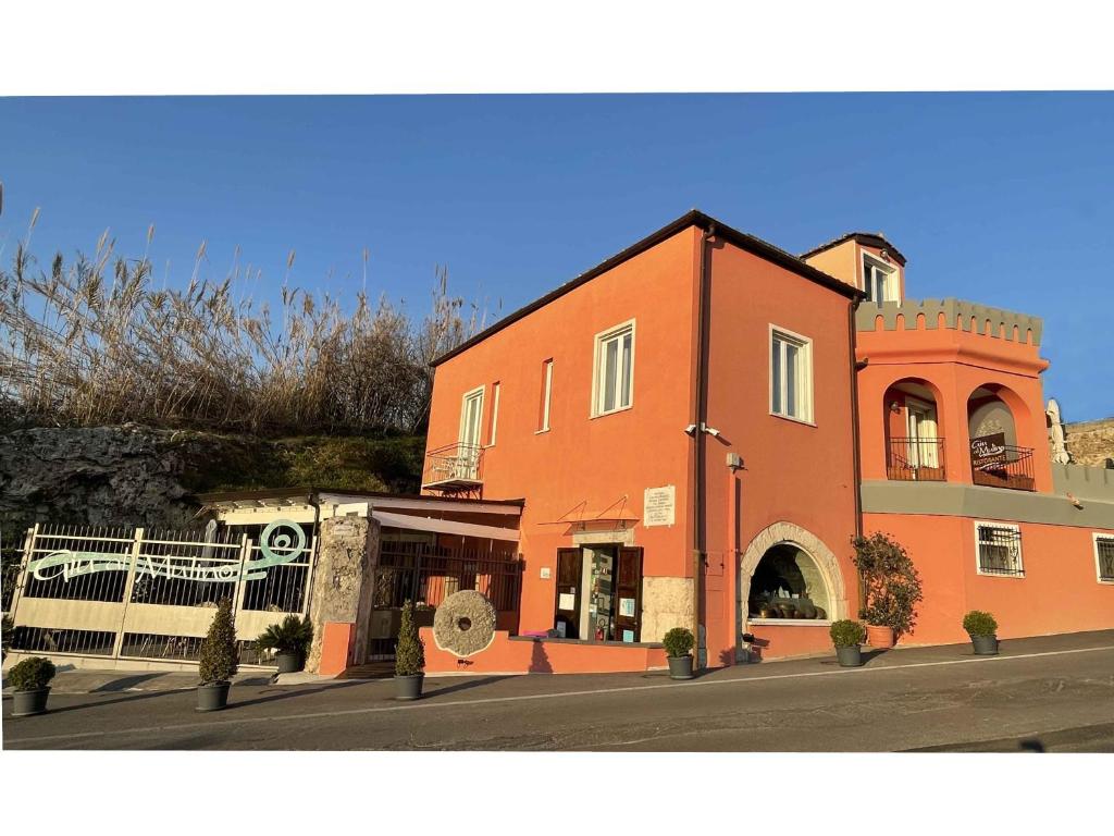 un grand bâtiment orange sur le côté d'une rue dans l'établissement Giu al Mulino, à Pontecagnano