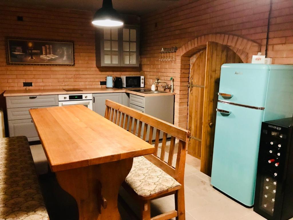 a kitchen with a wooden table and a refrigerator at Veselý - vinný sklep in Moravská Nová Ves