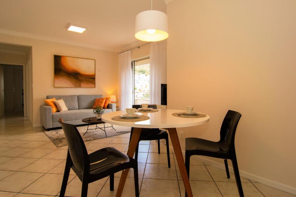 a living room with a table and chairs and a couch at Apto de 2 quartos a 100 mts da UFSC, Bela Vista P484 in Florianópolis