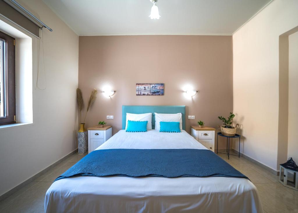 a bedroom with a large bed with blue pillows at Iro City and Beach Boutique Homes in Chania Town