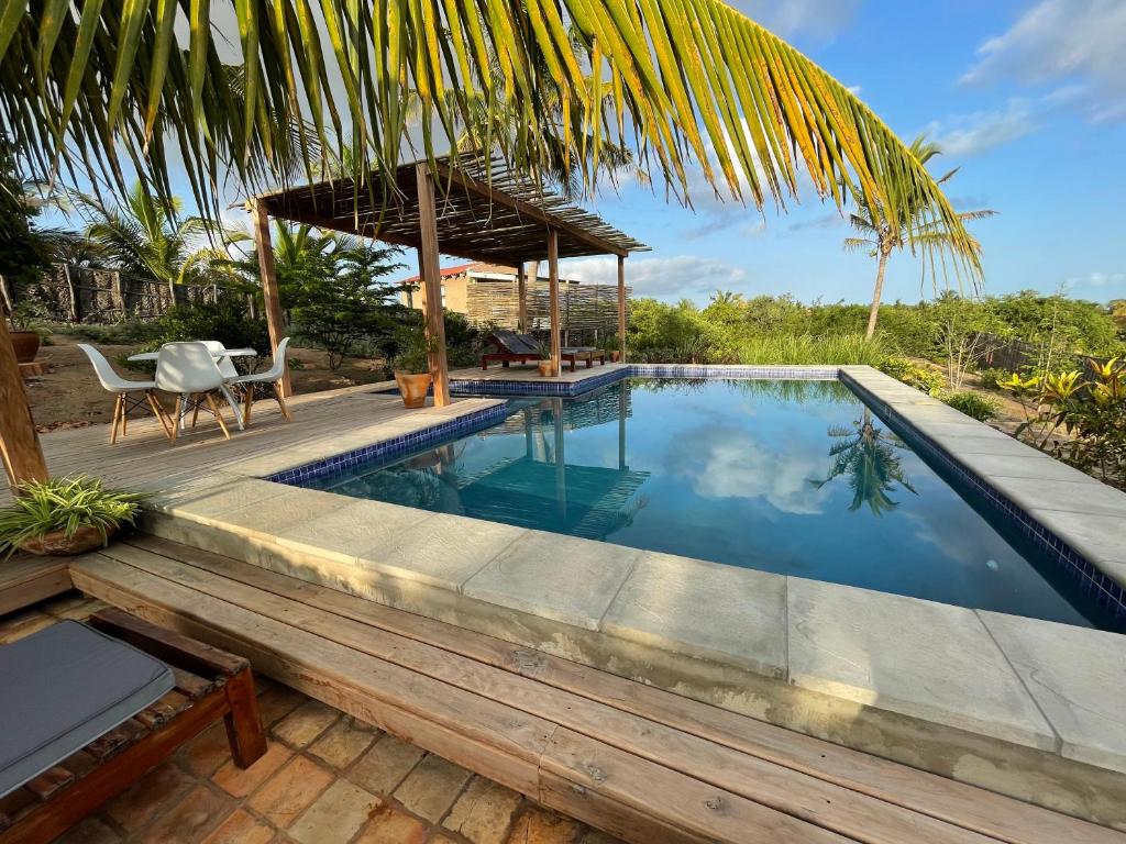 una piscina con terraza, mesa y sillas en Casa Naroo, en Praia do Tofo