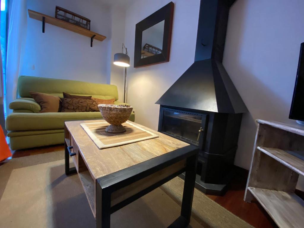 sala de estar con mesa y chimenea en Apartamento tranquilo Vielha Centro con Parking Gratuito en Vielha