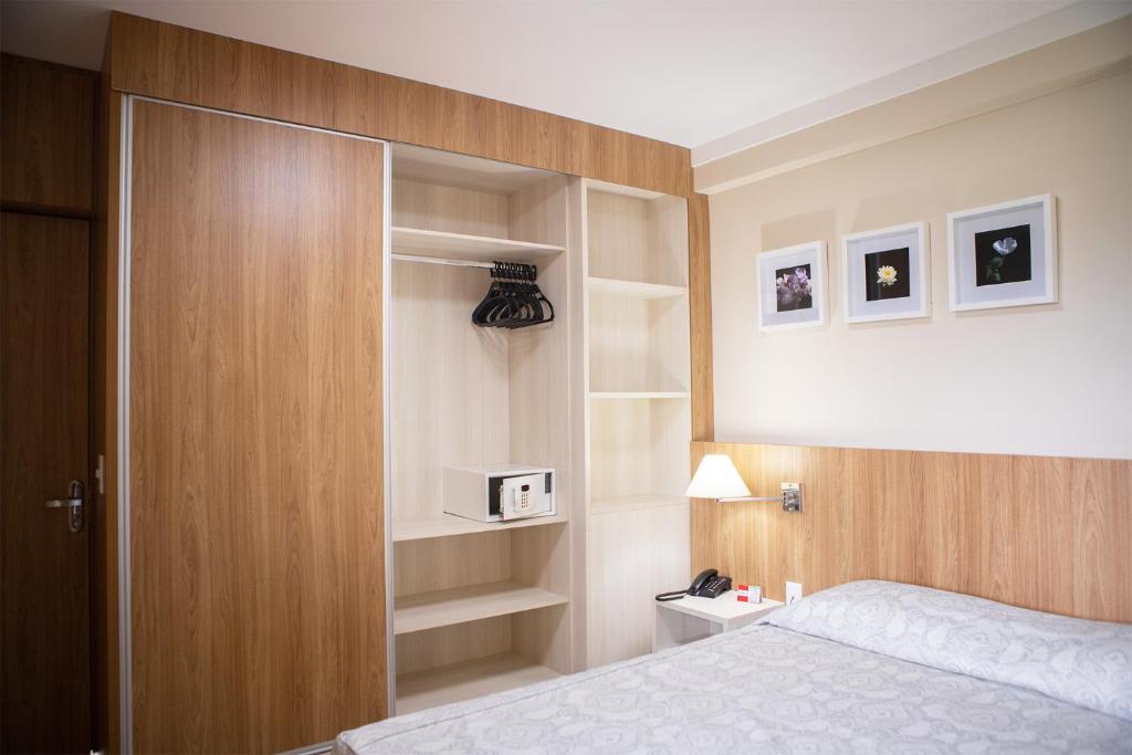 a bedroom with a bed and a cabinet with a microwave at CD PIAZZA COM ACQUA PARK in Caldas Novas