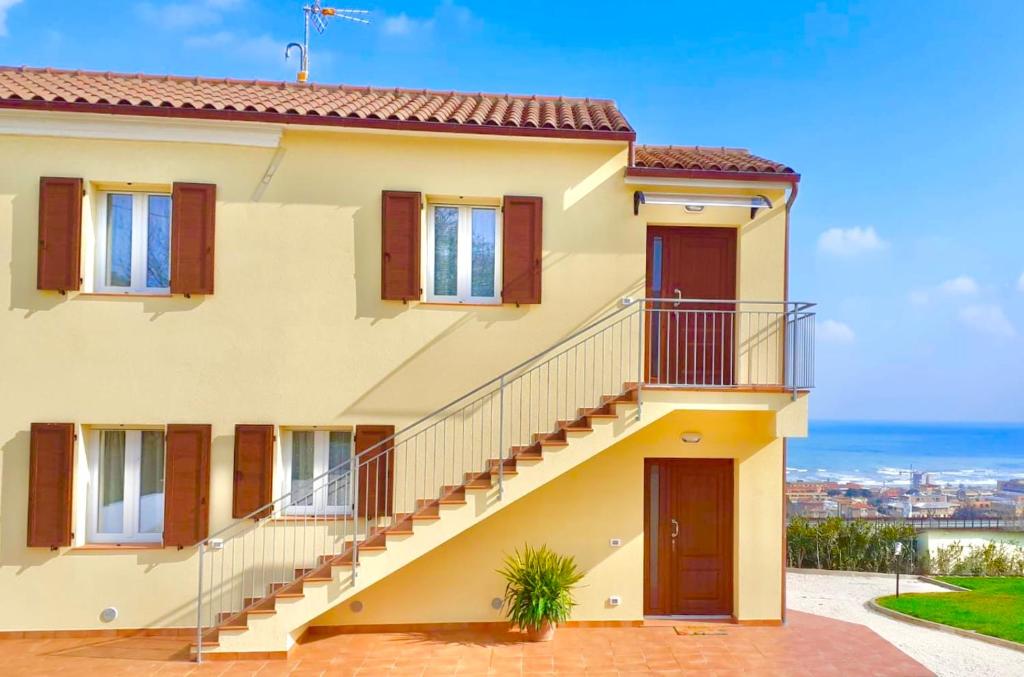 une maison avec des escaliers et une vue sur l'océan dans l'établissement Casa Vacanze con Vista Mare e Giardino - Amanecer, à Marzocca di Senigallia