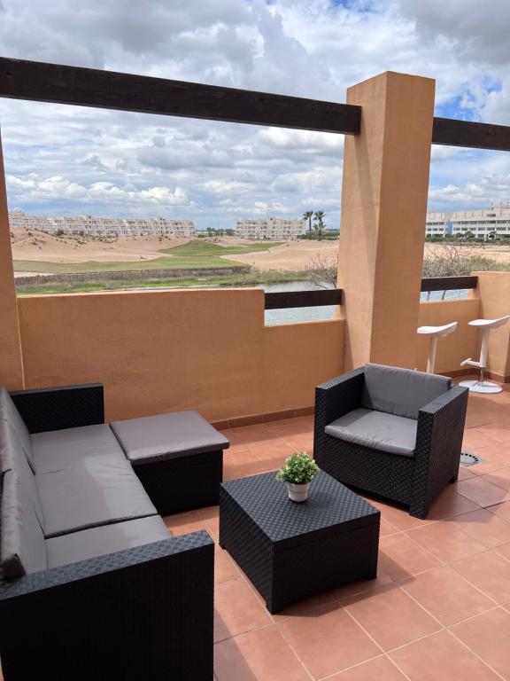 um pátio com sofás e cadeiras numa varanda em Apartment Las Terrazas de la Torre Golf,Pool,Lake View em Las Pedreñas