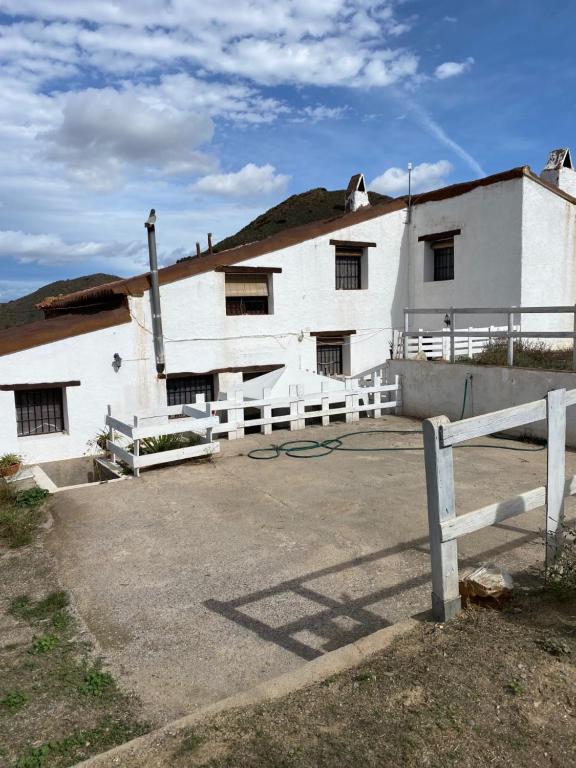a white building with a fence in front of it at Luby Cortijo El Horno in Lubrín