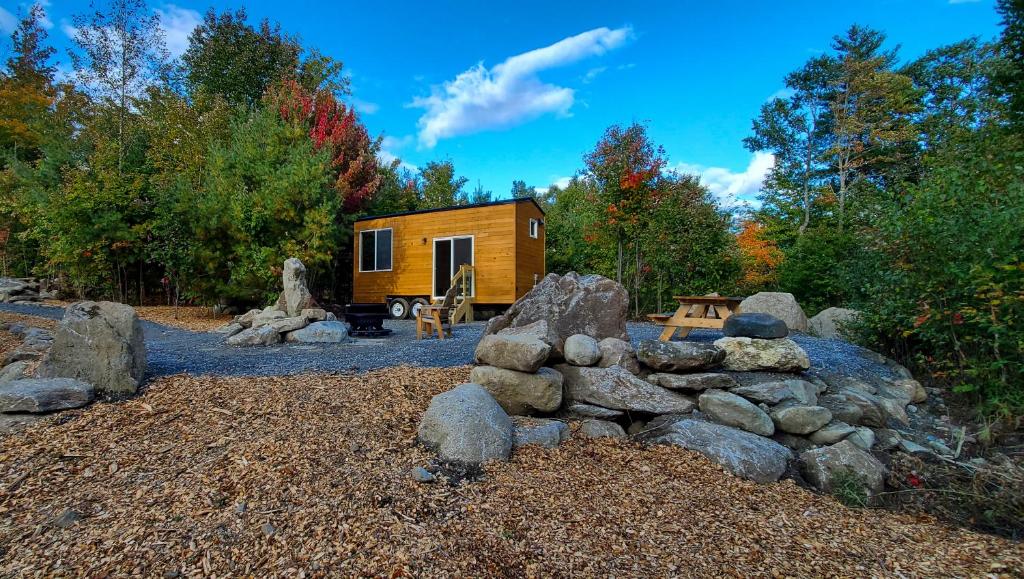 a tiny house with a pile of rocks at Trailside Stays in Rumney