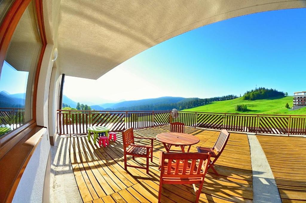 a patio with a table and chairs on a deck at Panorama Donovaly 22-C in Donovaly