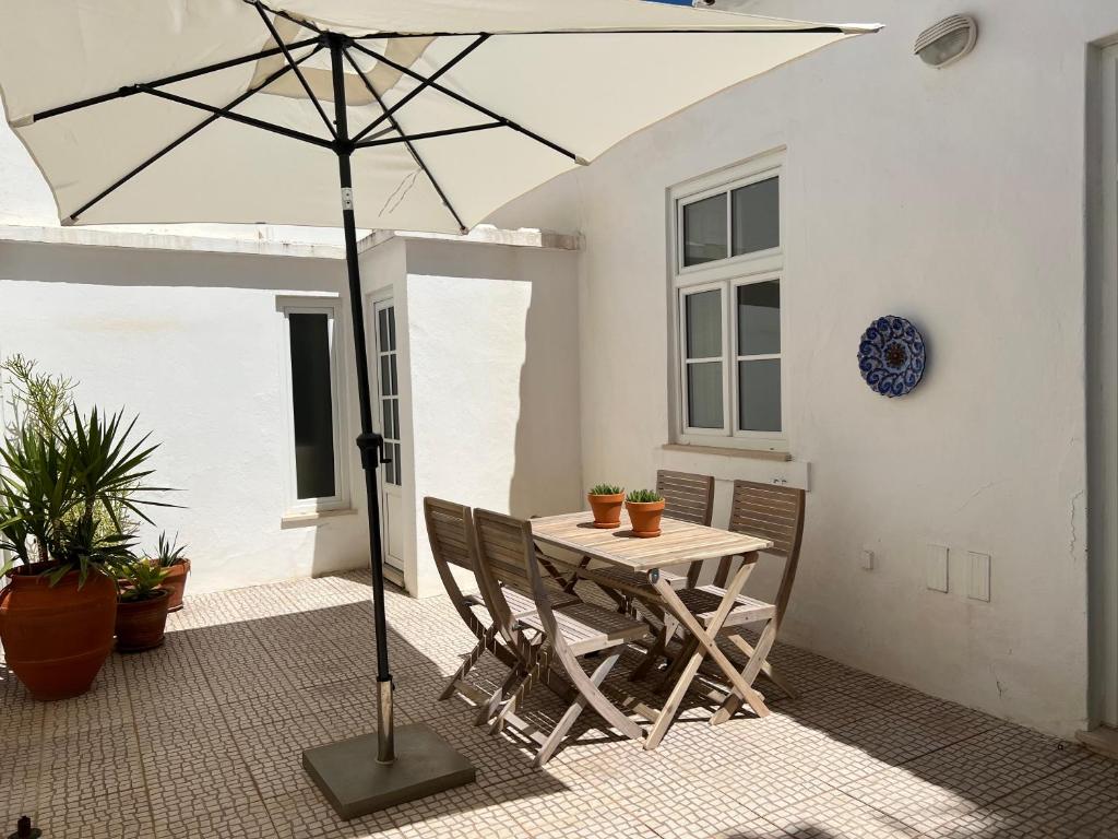 einen Tisch und Stühle mit Sonnenschirm auf einer Terrasse in der Unterkunft Santa Clara Old Town in Albufeira