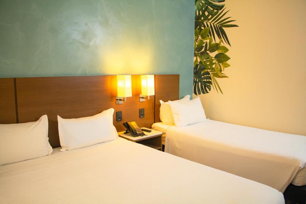 Postel nebo postele na pokoji v ubytování ibis Styles Curitiba Aeroporto