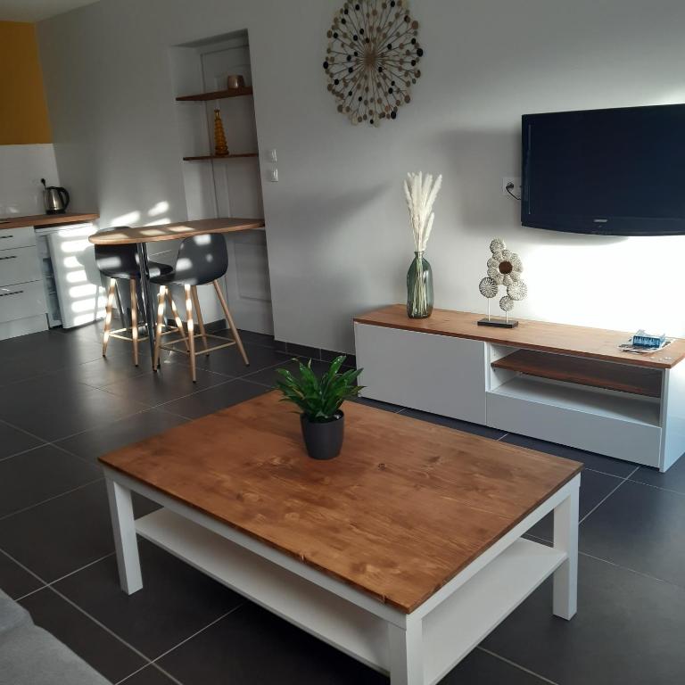 a living room with a table and a tv at LE STUDIO DE FLAVIA in Alençon