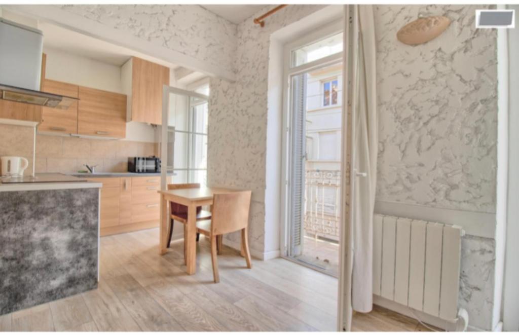 une cuisine avec une table en bois et une salle à manger dans l'établissement Studio équipé-climatisé avec balcon au Mourillon à 20m de la plage, à Toulon